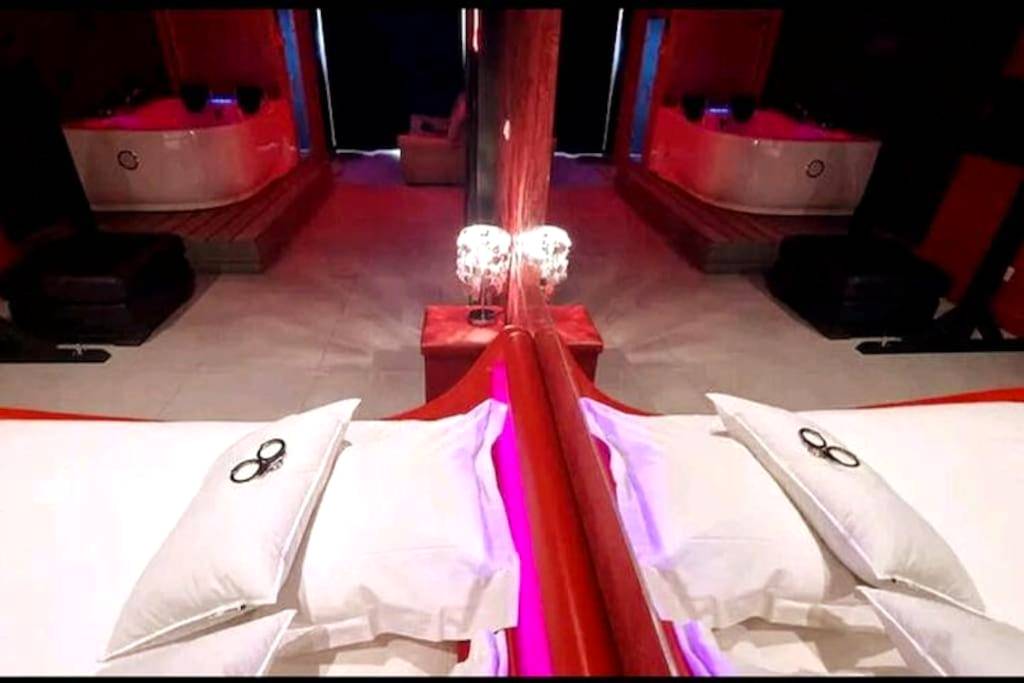 Miroir au - dessus du lit et jacuzzi en fond - Love Room Mauguio - Appartement balnéo et sauna privés The Red Room