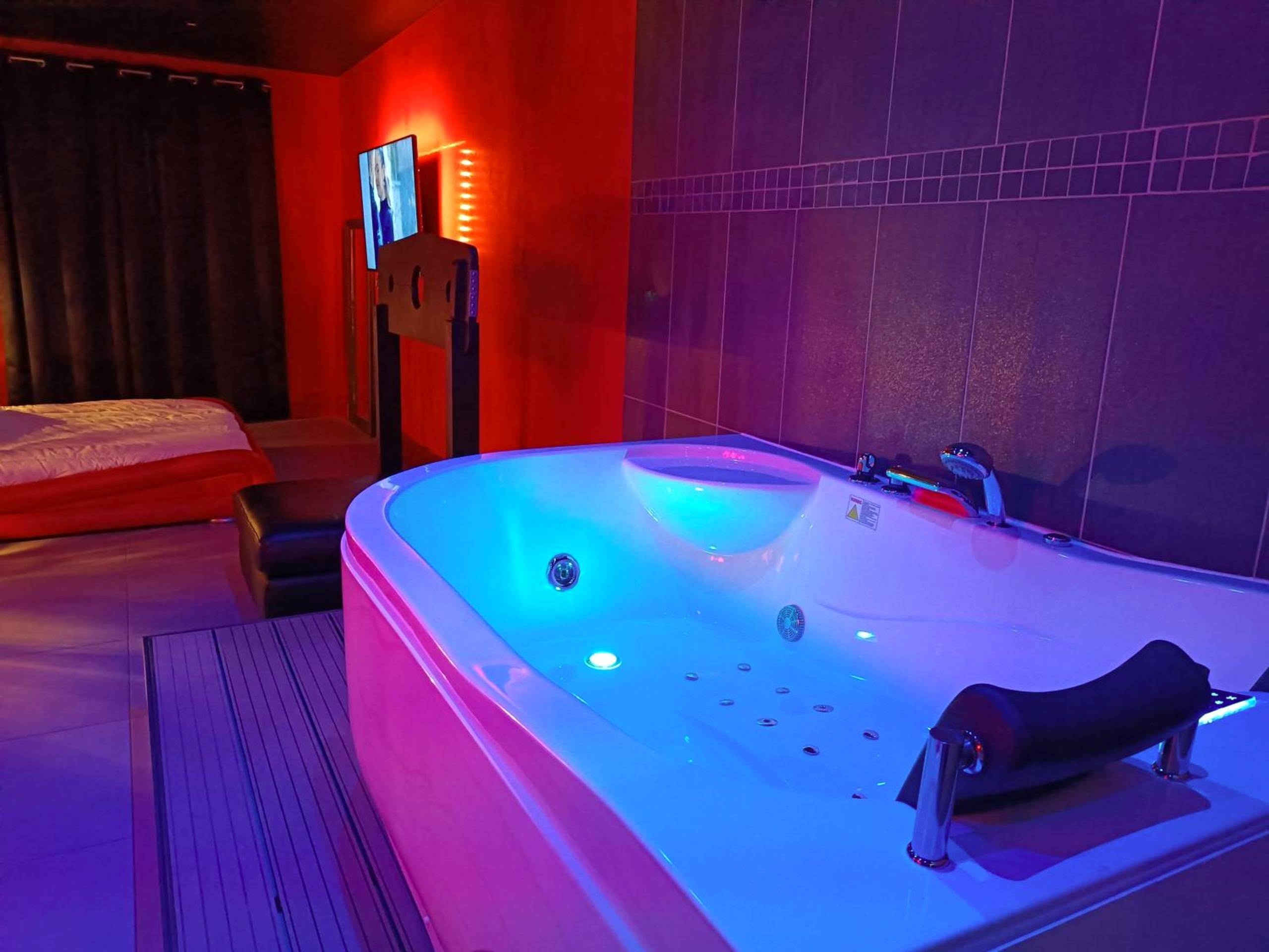 Jacuzzi privatif avec éclairage LED bleu - Appartement balnéo et sauna privés The Red Room