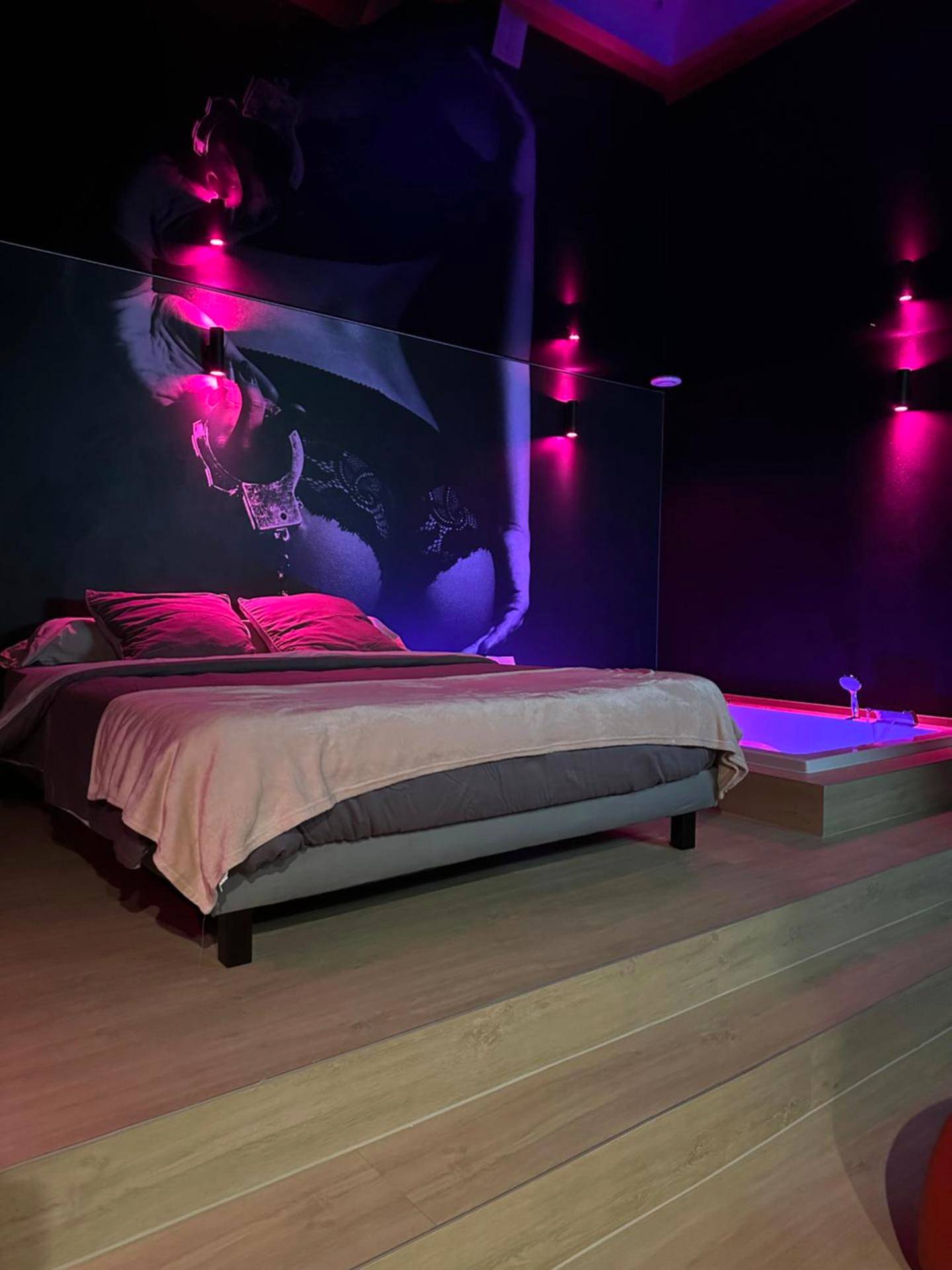 Lit double sur estrade face à un mur décoré - L'Écrin de Saint - Red Room by Loveroomeo