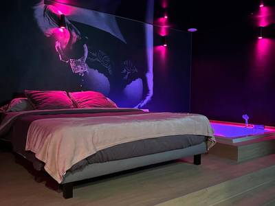 Lit double sur estrade face à un mur décoré - L'Écrin de Saint - Red Room by Loveroomeo