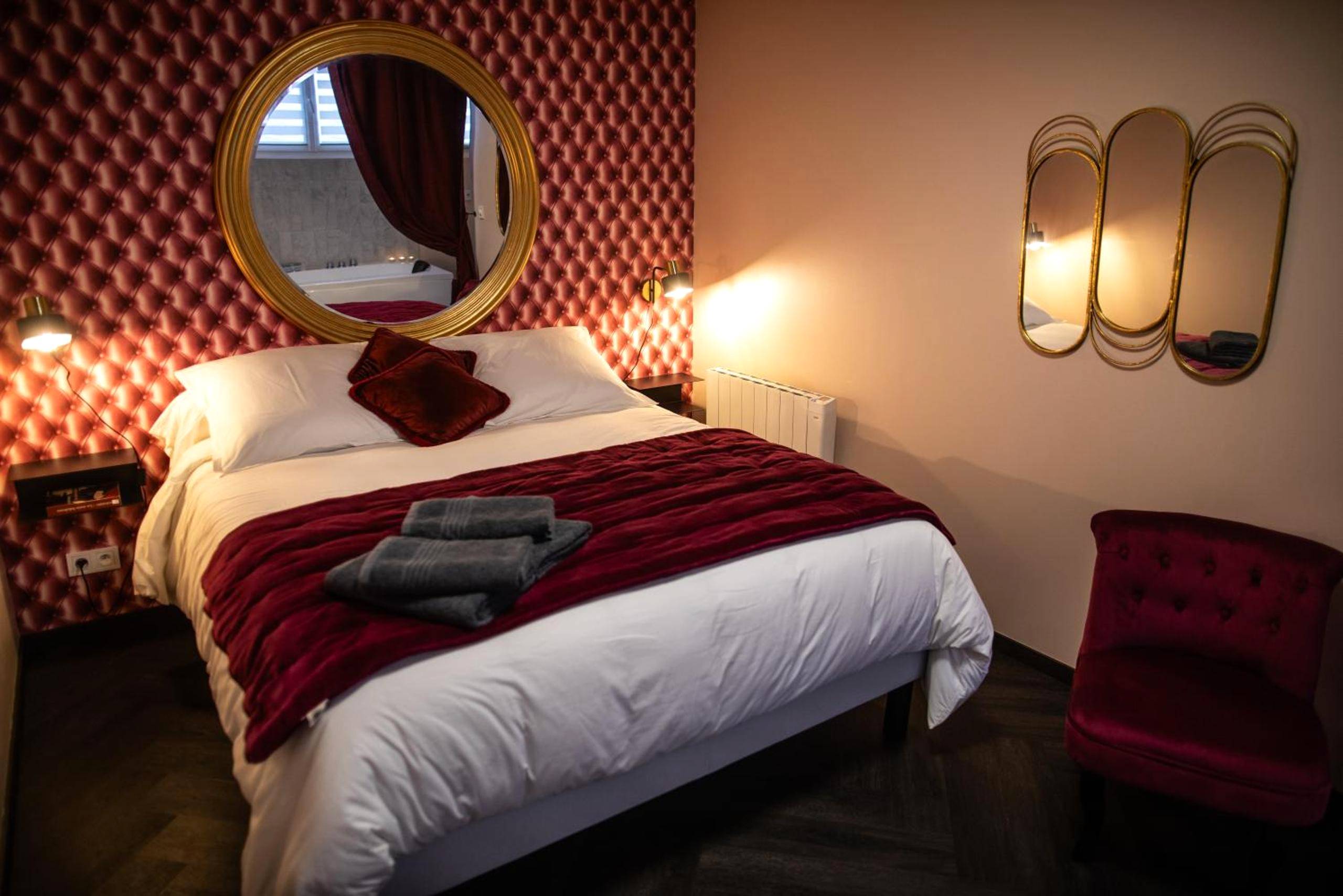 Lit double avec mur capitonné et miroir doré - Love Room Sainte - Adresse - Reflet des sens Love & Balnéo