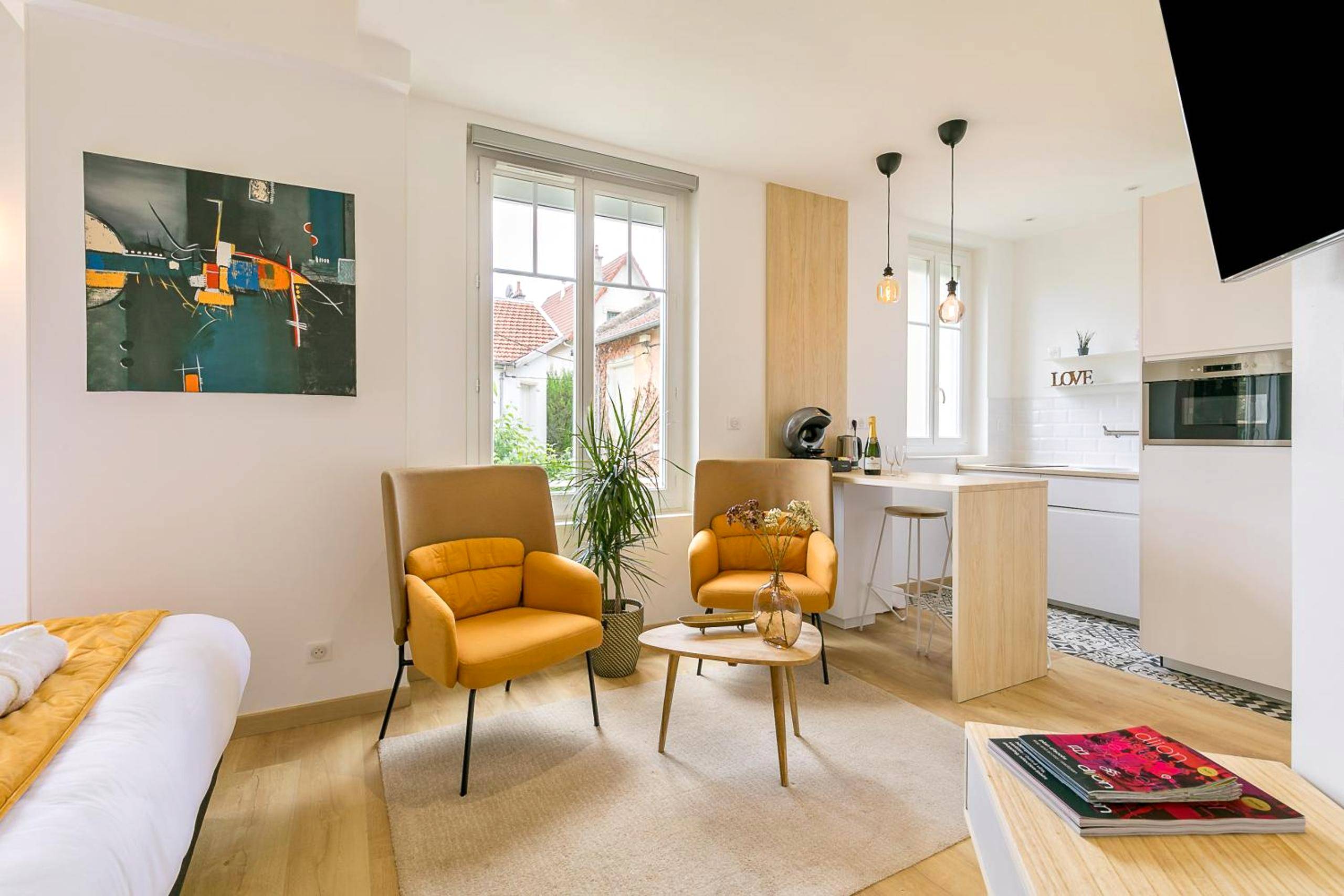 Salon moderne avec fauteuils jaunes et cuisine - Relax Spa, avec jacuzzi à Dijon