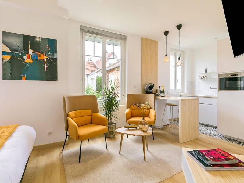 Salon moderne avec fauteuils jaunes et cuisine - Relax Spa, avec jacuzzi à Dijon