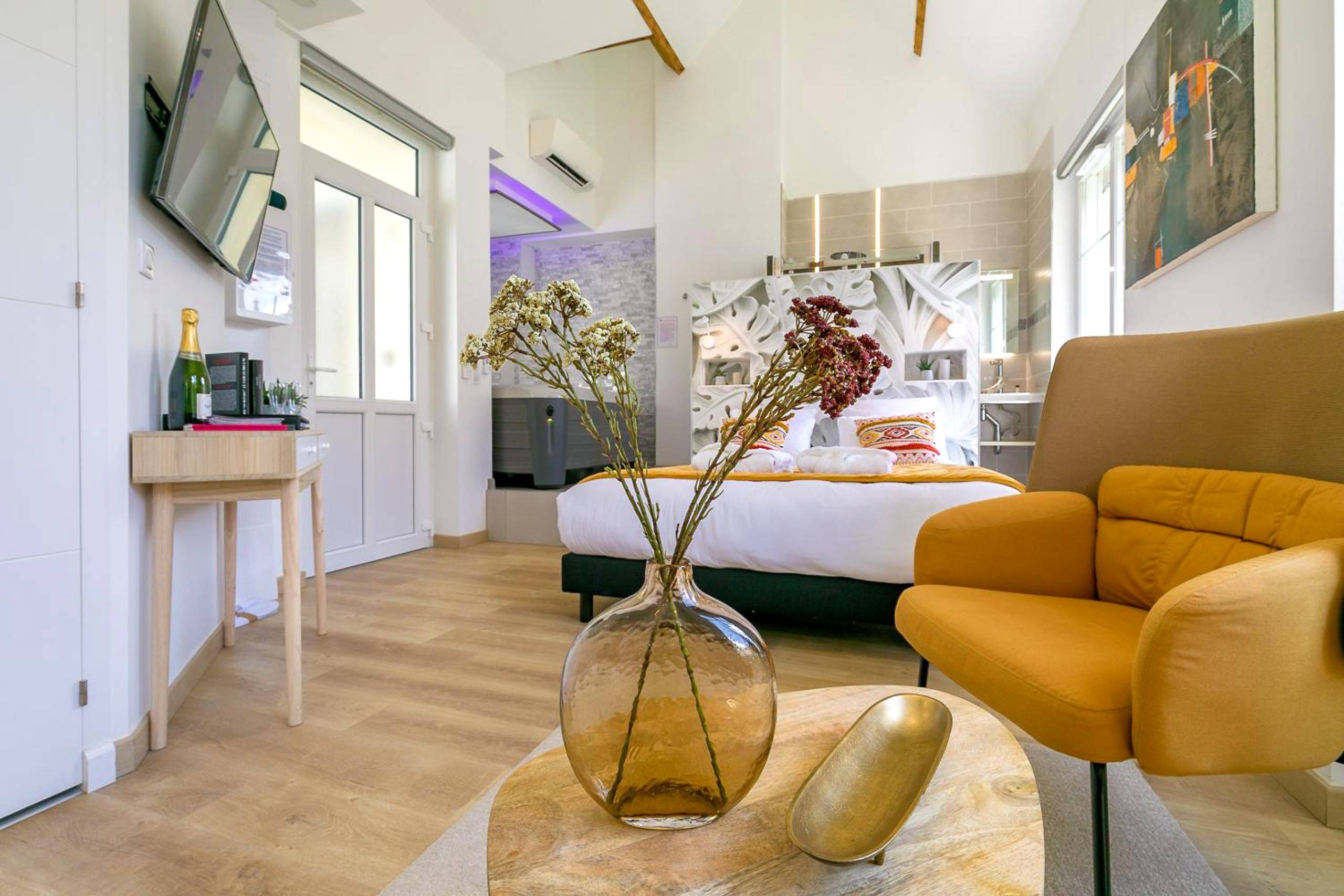 Vue d'ensemble du studio avec coin salon et lit - Relax Spa, avec jacuzzi à Dijon