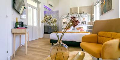 Vue d'ensemble du studio avec coin salon et lit - Relax Spa, avec jacuzzi à Dijon