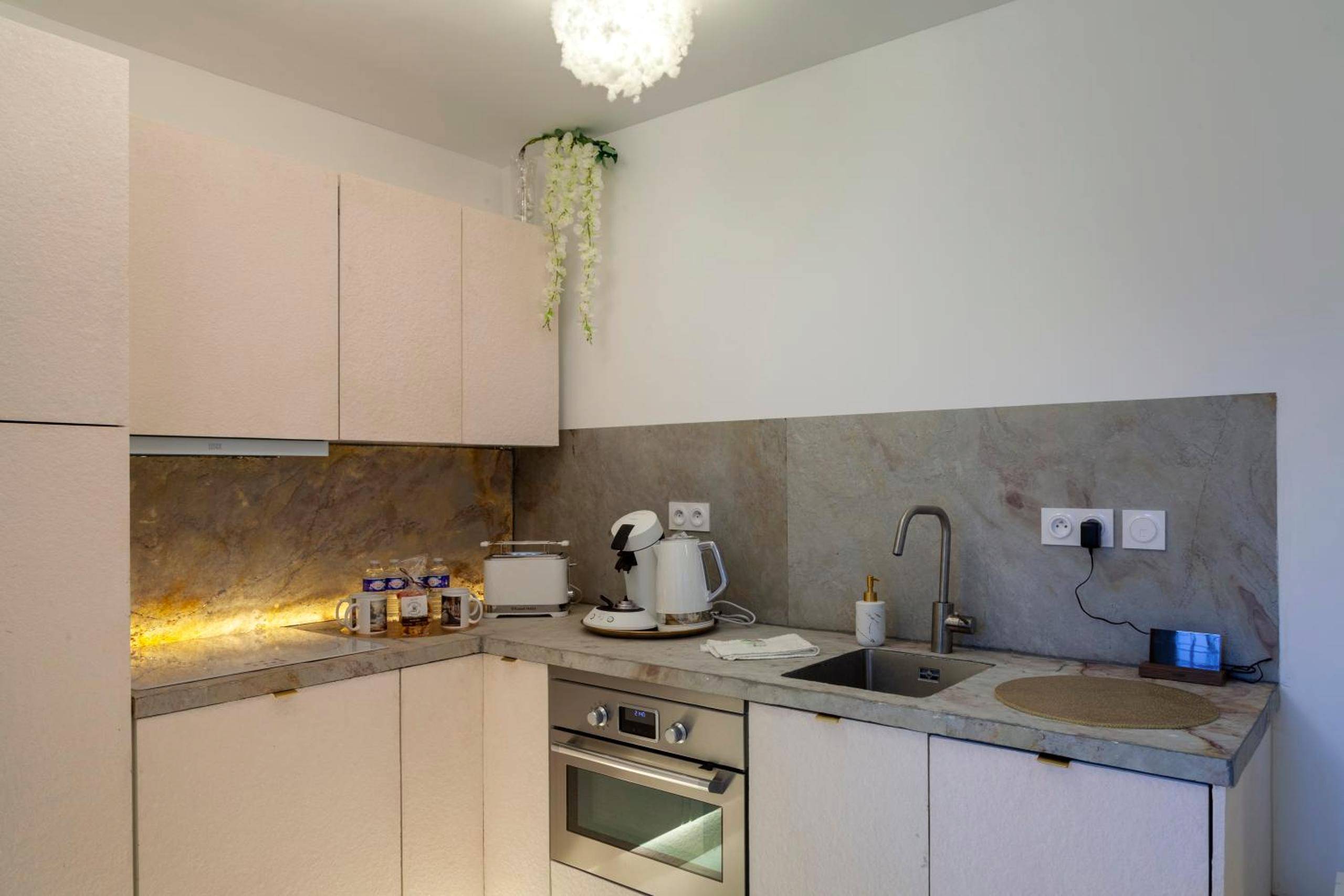 Cuisine équipée moderne avec crédence en pierre - La Rêverie : Sauna Privé Jacuzzi et Table Massage