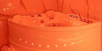 Jacuzzi d'angle avec néon décoratif - La Rêverie : Sauna Privé Jacuzzi et Table Massage
