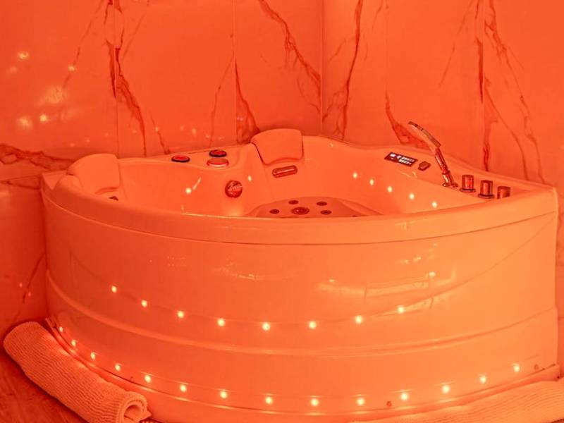 Jacuzzi d'angle avec néon décoratif - La Rêverie : Sauna Privé Jacuzzi et Table Massage