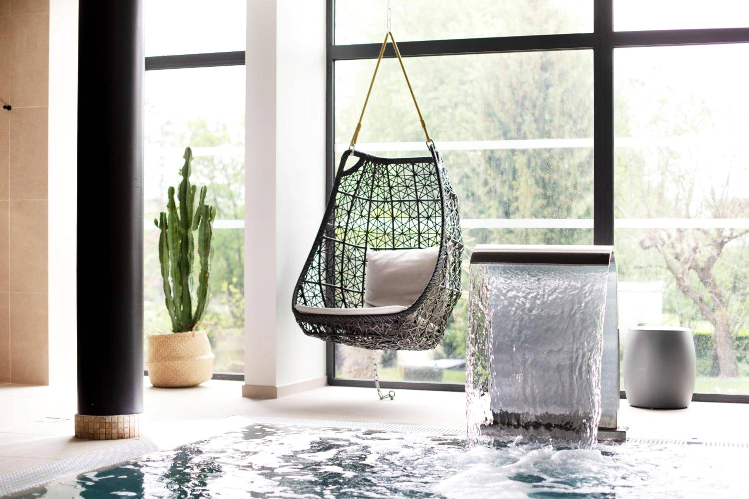 Fauteuil suspendu face à une piscine intérieure - Love Room Vosne - Romanée - Le Richebourg Hôtel, Restaurant & Spa