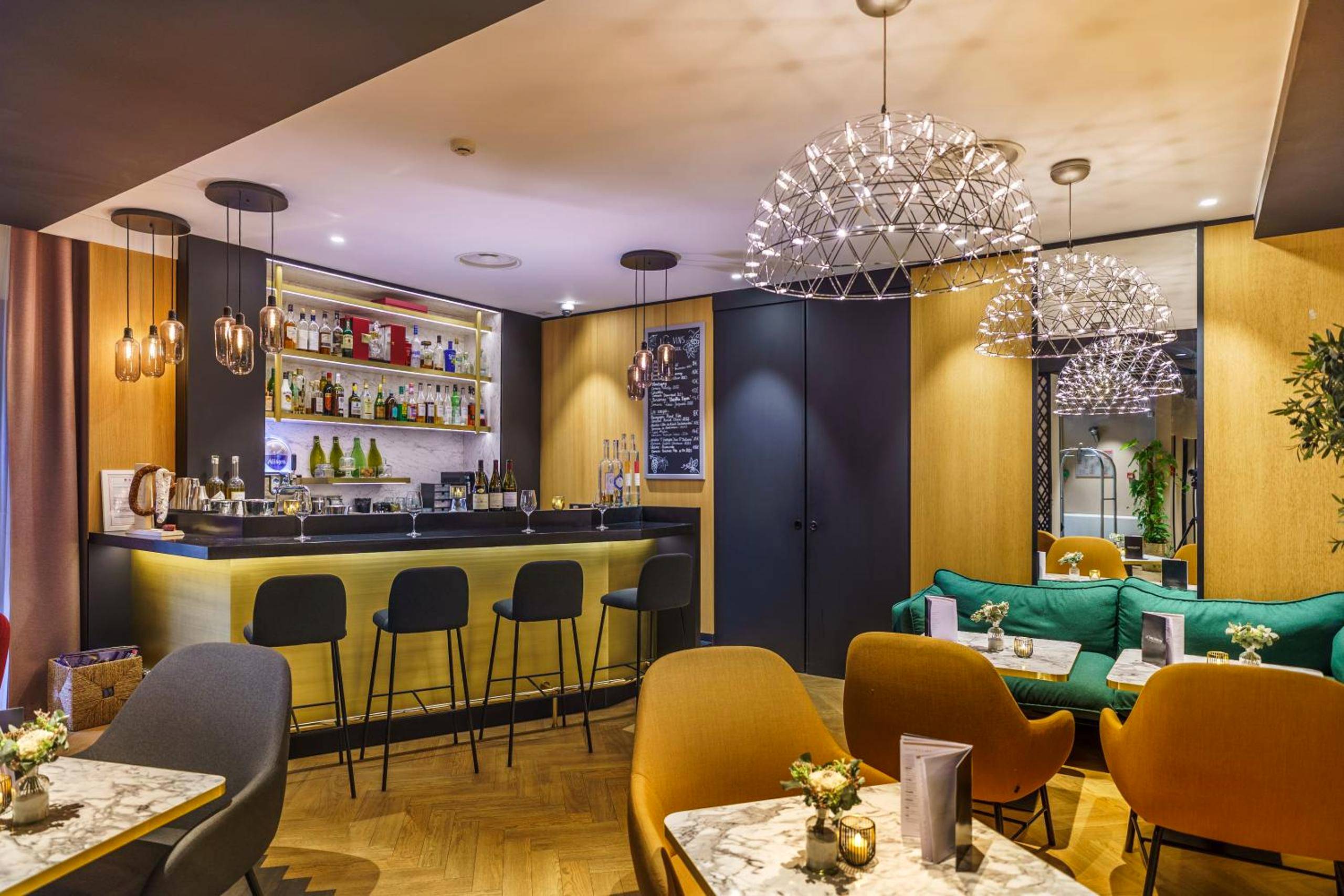 Bar lounge avec comptoir éclairé et fauteuils - Le Richebourg Hôtel, Restaurant & Spa