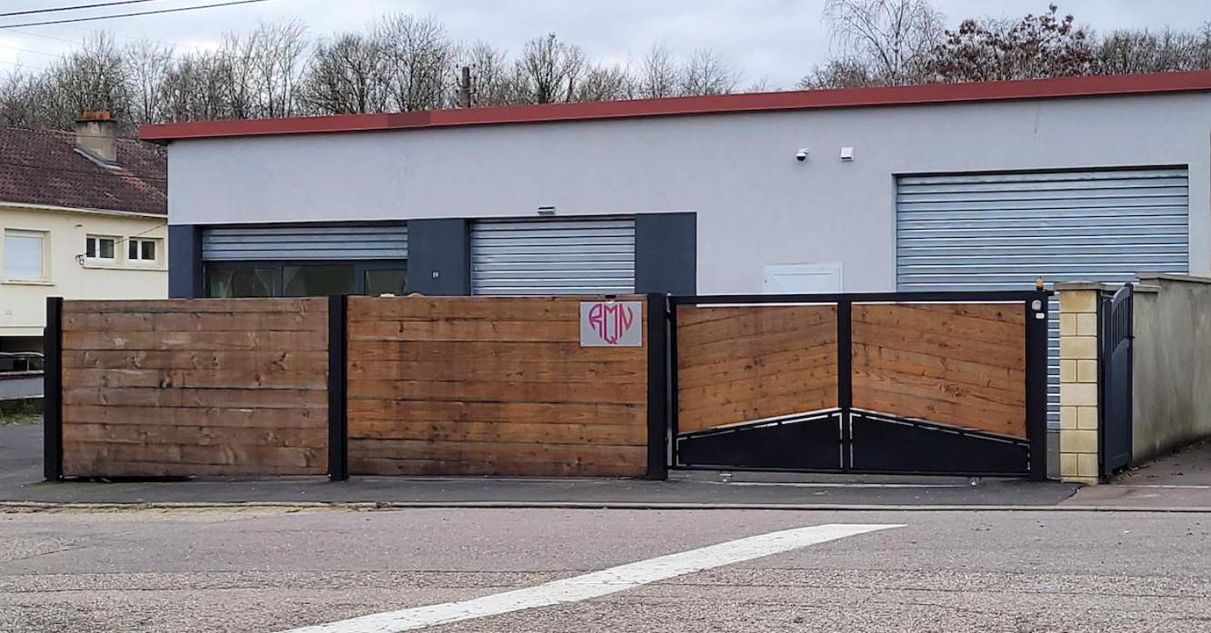 Vue extérieure du bâtiment avec portail en bois - Rien Que Nous