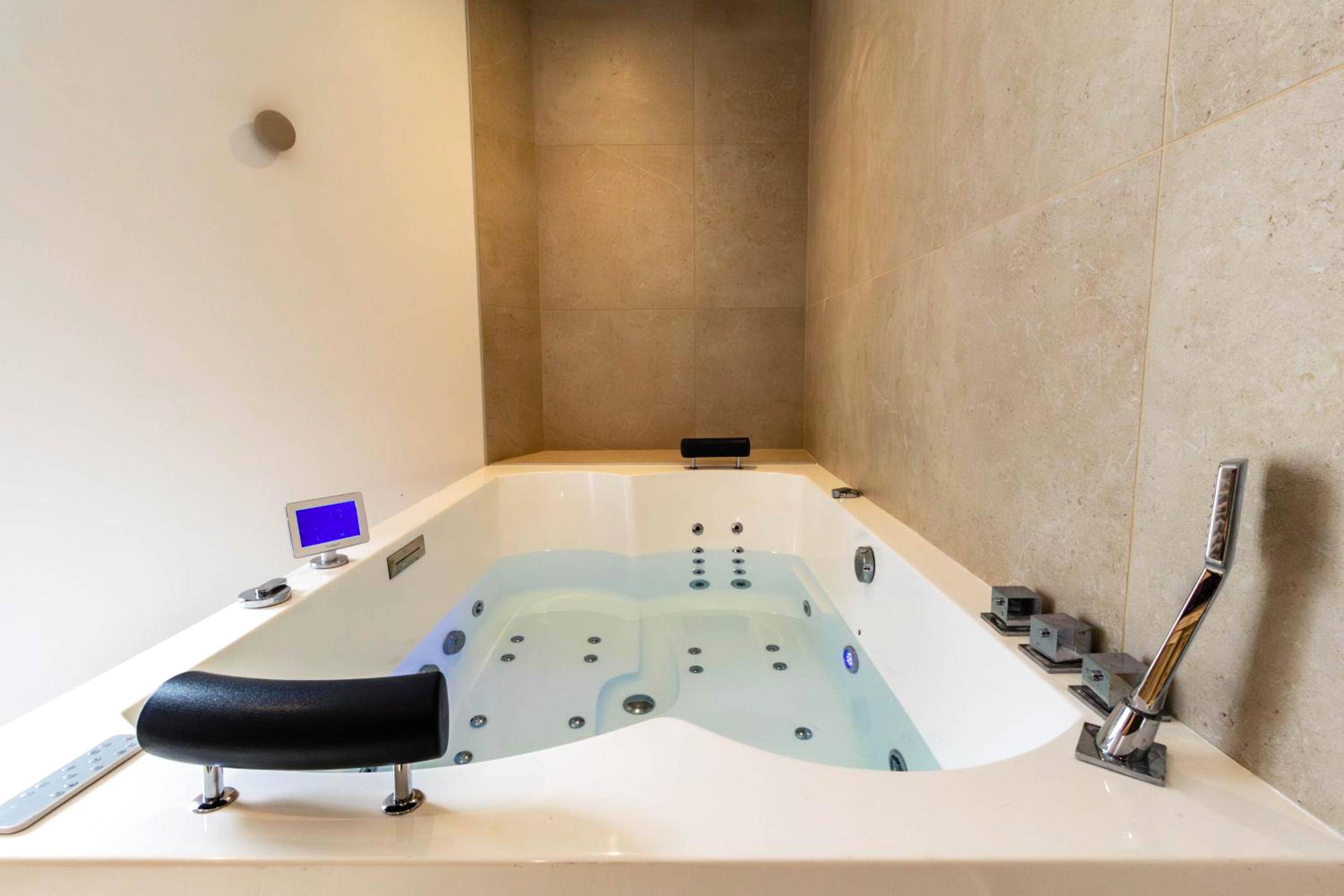 Salon avec canapé bleu et mur en pierre - Romance & Evasion - Centre Ville - Love Room - Balnéo