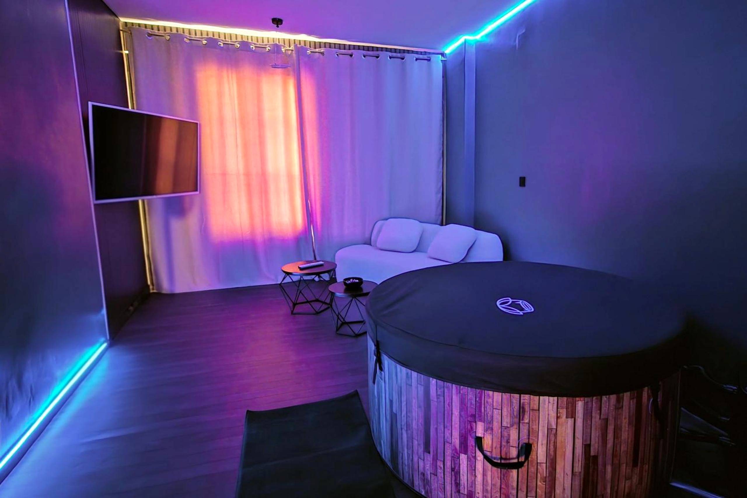 Salon avec jacuzzi et éclairage néon bleu - Love Room Metz - Suite Romanting Metz Centre Private Spa