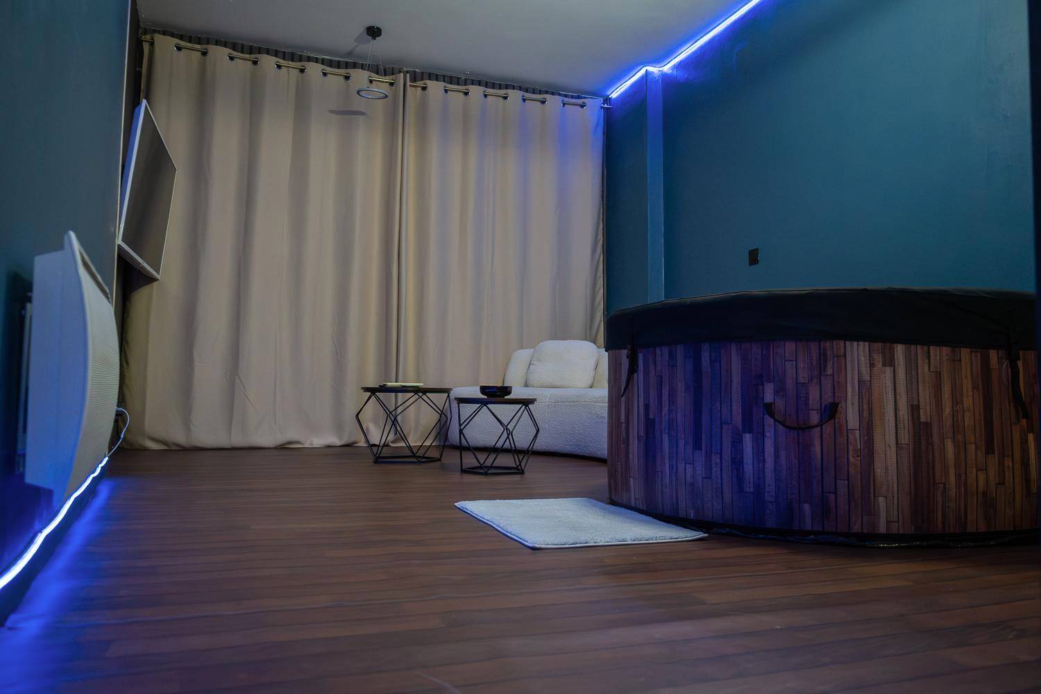 Espace détente avec jacuzzi et canapé blanc - Suite Romanting Metz Centre Private Spa