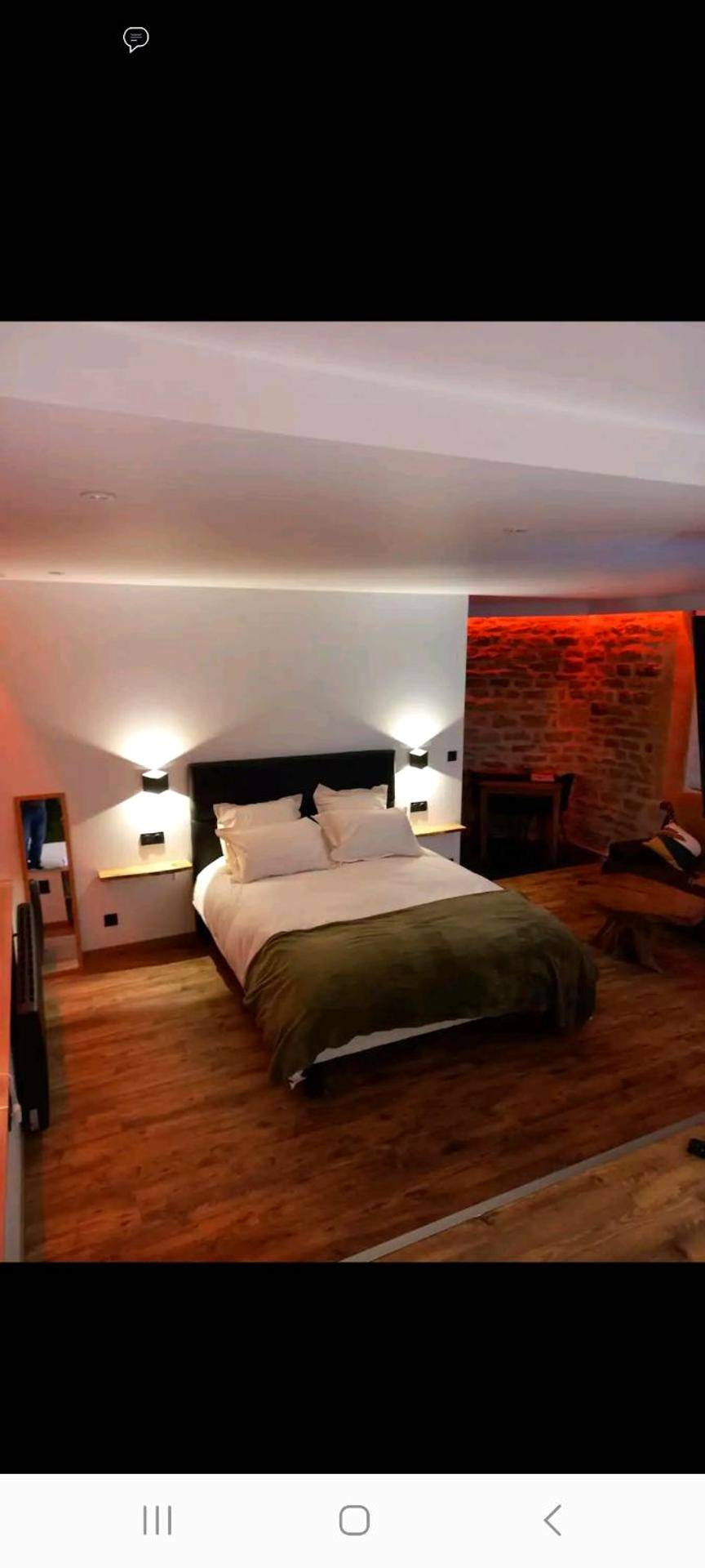 Lit double sur parquet avec mur en pierre - Romantique room