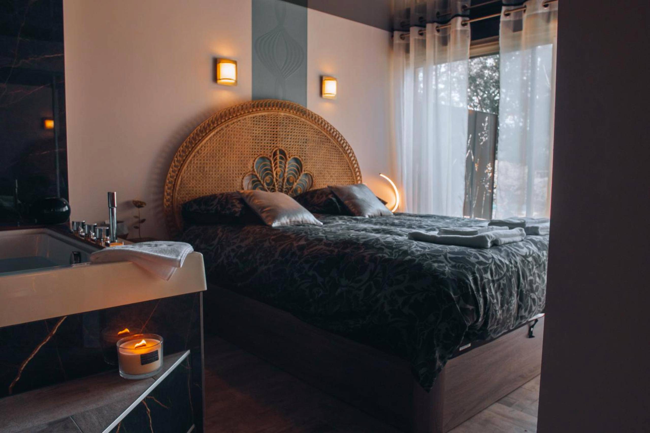 Chambre avec lit double et tête de lit en rotin - La Ronde des Bois - Romance et Bien Être - Jacuzzi privatif - piscine...