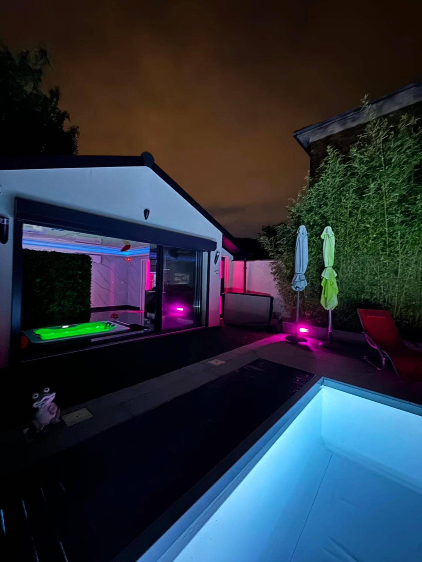Piscine extérieure et terrasse éclairées de nuit - Love Room Noisiel - Love Room Romantique