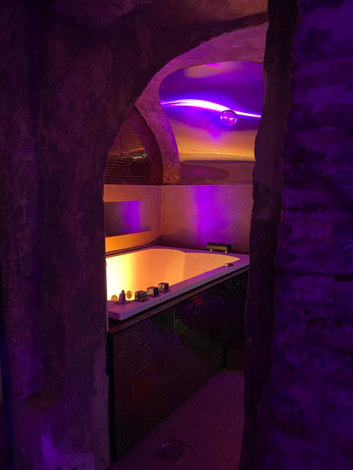 Baignoire balnéo sous voûte en pierre - Love Room Lille - Private Room & Spa avec jacuzzi privatif