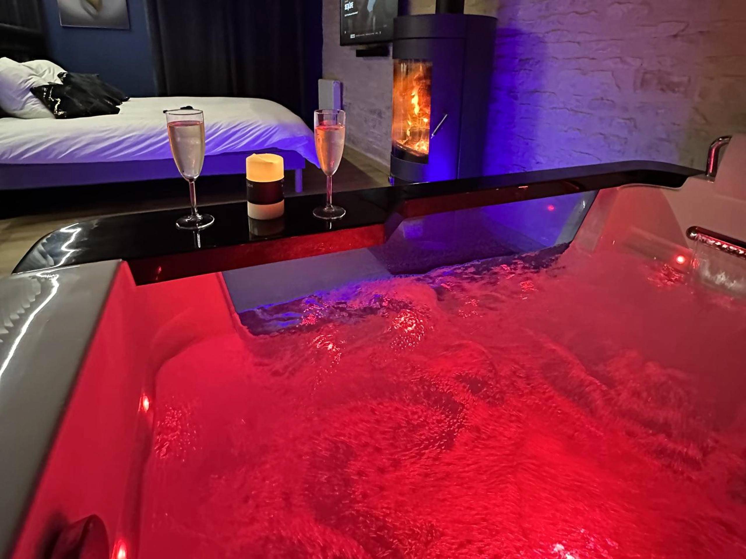 Espace salon avec table ronde et jacuzzi - RoomAndX - LoveRoom - Caen - Bayeux