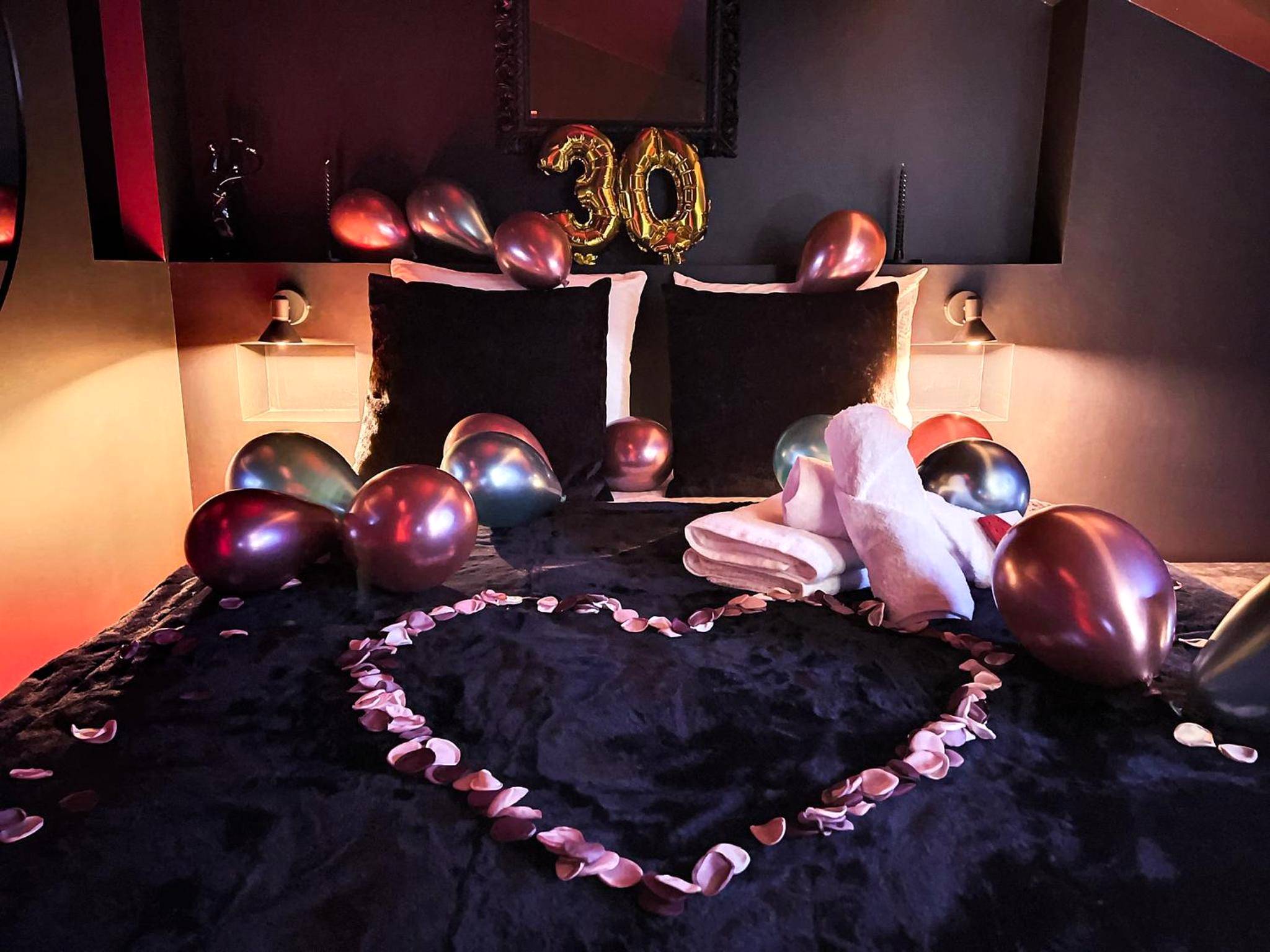 Décoration d'anniversaire avec ballons sur le lit - Suite Rouge baiser avec Jacuzzi privatif - LoveRoom Insolite