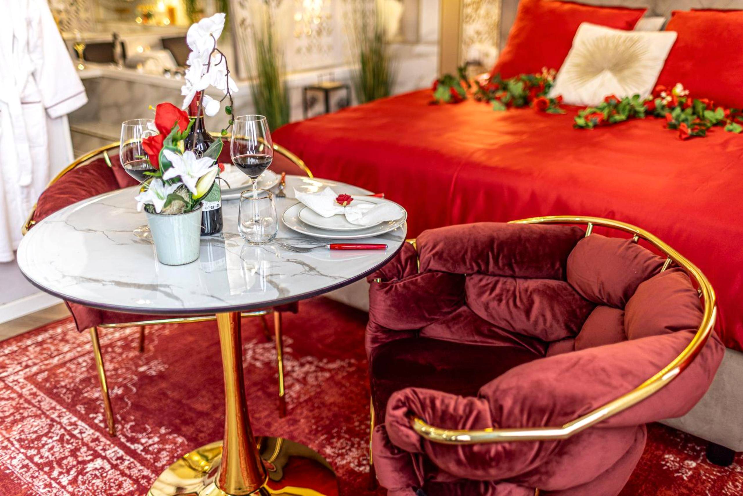 Table dressée avec vin devant lit king size - Le Rubis - Love Room Romantique