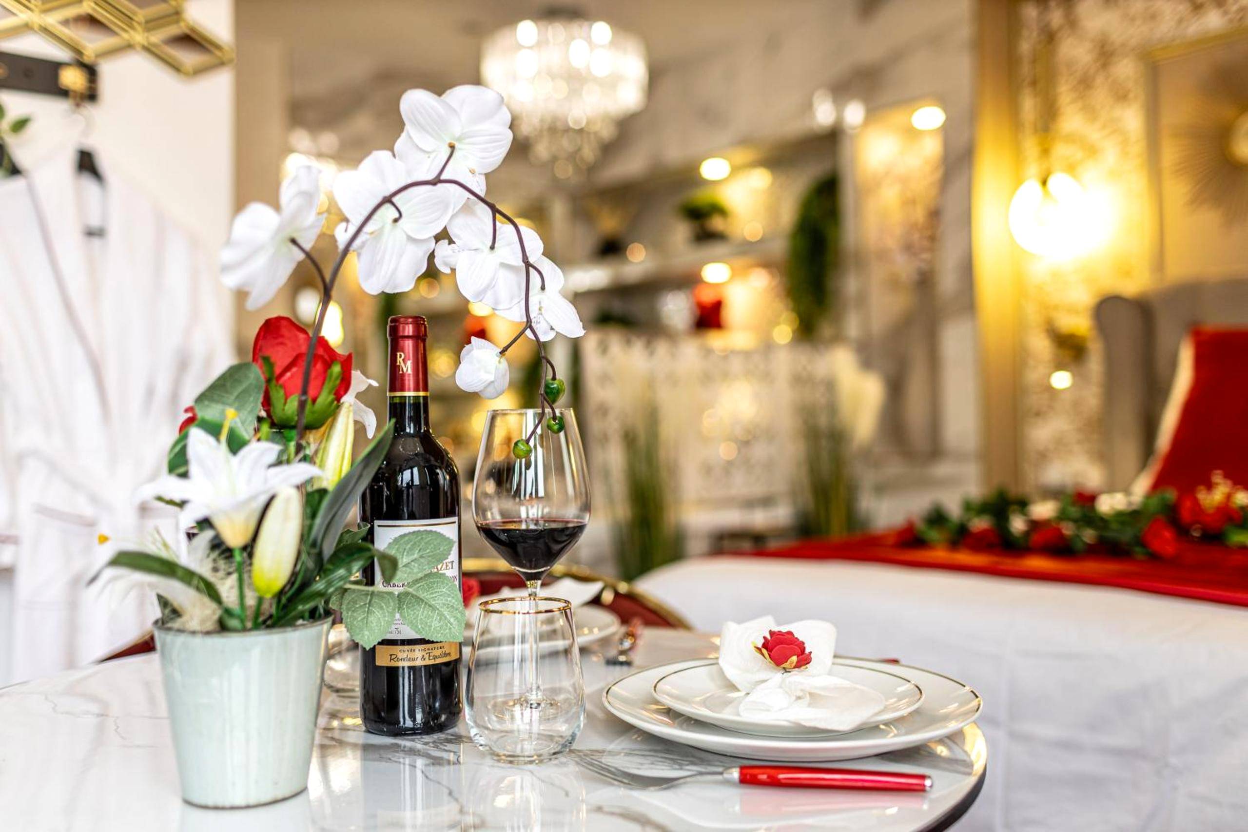 Détail de table avec bouteille de vin et fleurs - Le Rubis - Love Room Romantique