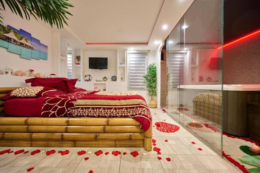 Lit en bambou avec pétales de rose au sol - Love Room Toulouse - Sablotin SPA