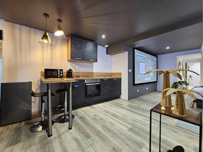 Cuisine équipée avec coin repas et écran géant - Balnéo et Cinéma Le Saona