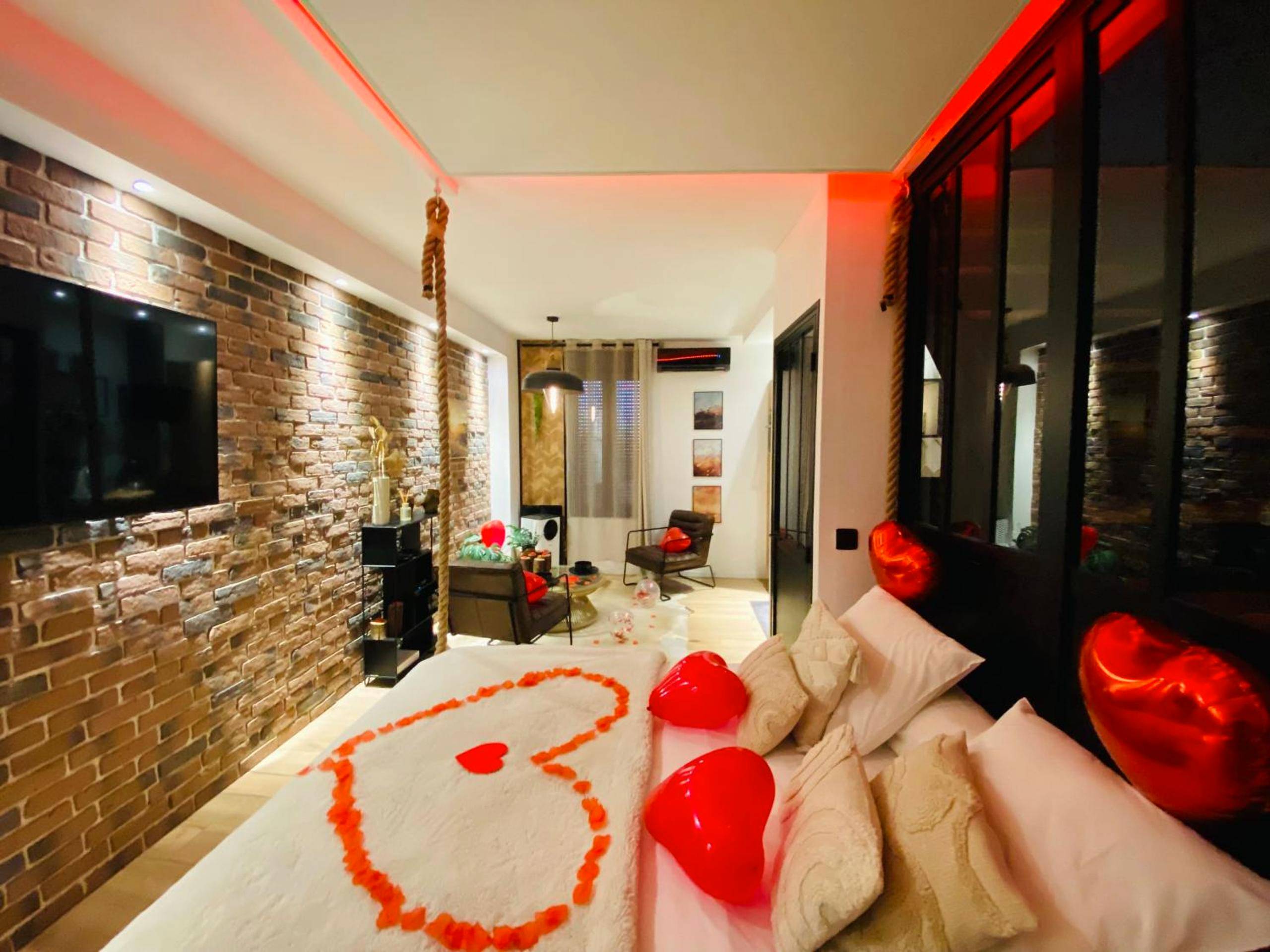 Lit avec pétales de rose et ballons cœurs - Love Room Amiens - Saphir Spa - Sauna Balnéo Chromothérapie Massage