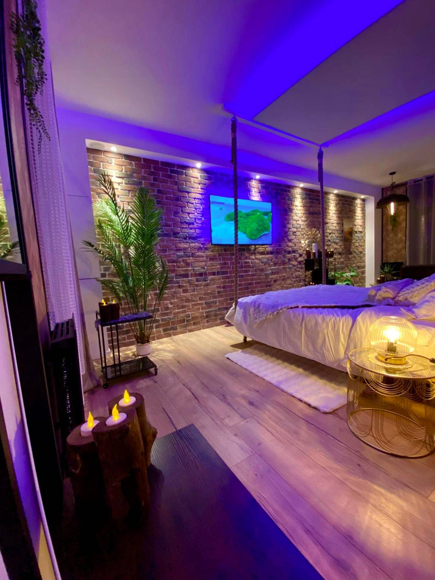 Lit suspendu dans une ambiance lumineuse violette - Saphir Spa - Sauna Balnéo Chromothérapie Massage