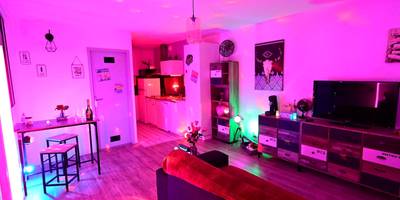 Salon et cuisine ouverte avec lumières roses - Luxe Sauna Privatif et Grand bain Jacuzzi à deux à Biscarosse Plage pour...