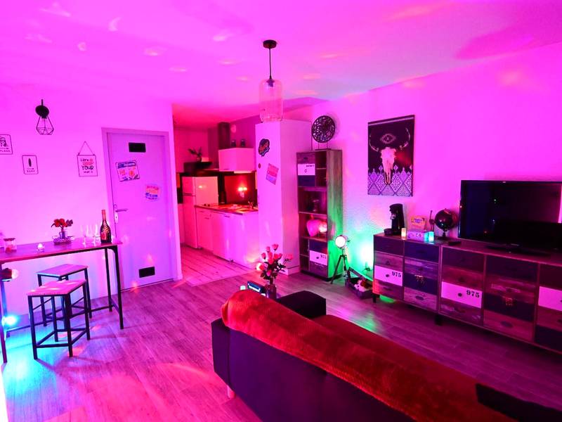 Salon et cuisine ouverte avec lumières roses - Luxe Sauna Privatif et Grand bain Jacuzzi à deux à Biscarosse Plage pour...