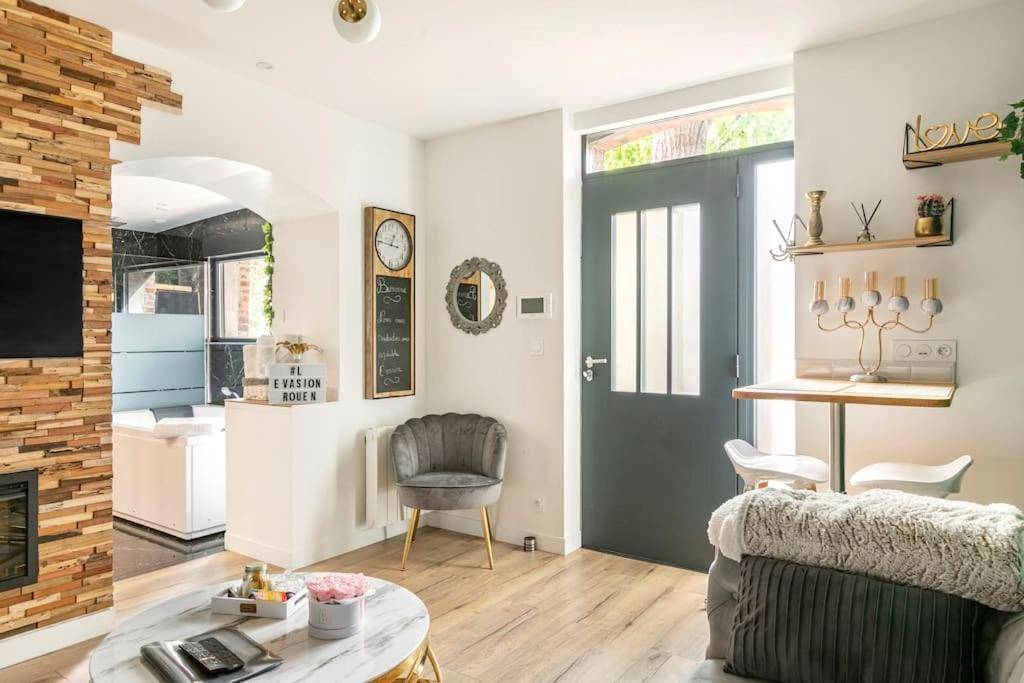 Salon lumineux avec fauteuil et coin repas - Sauna, jacuzzi, terrasse et parking