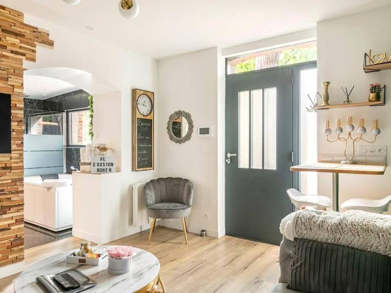 Salon lumineux avec fauteuil et coin repas - Sauna, jacuzzi, terrasse et parking