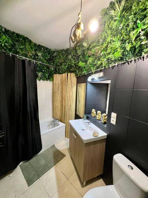 Salle de bain avec mur végétal et baignoire - la savane room