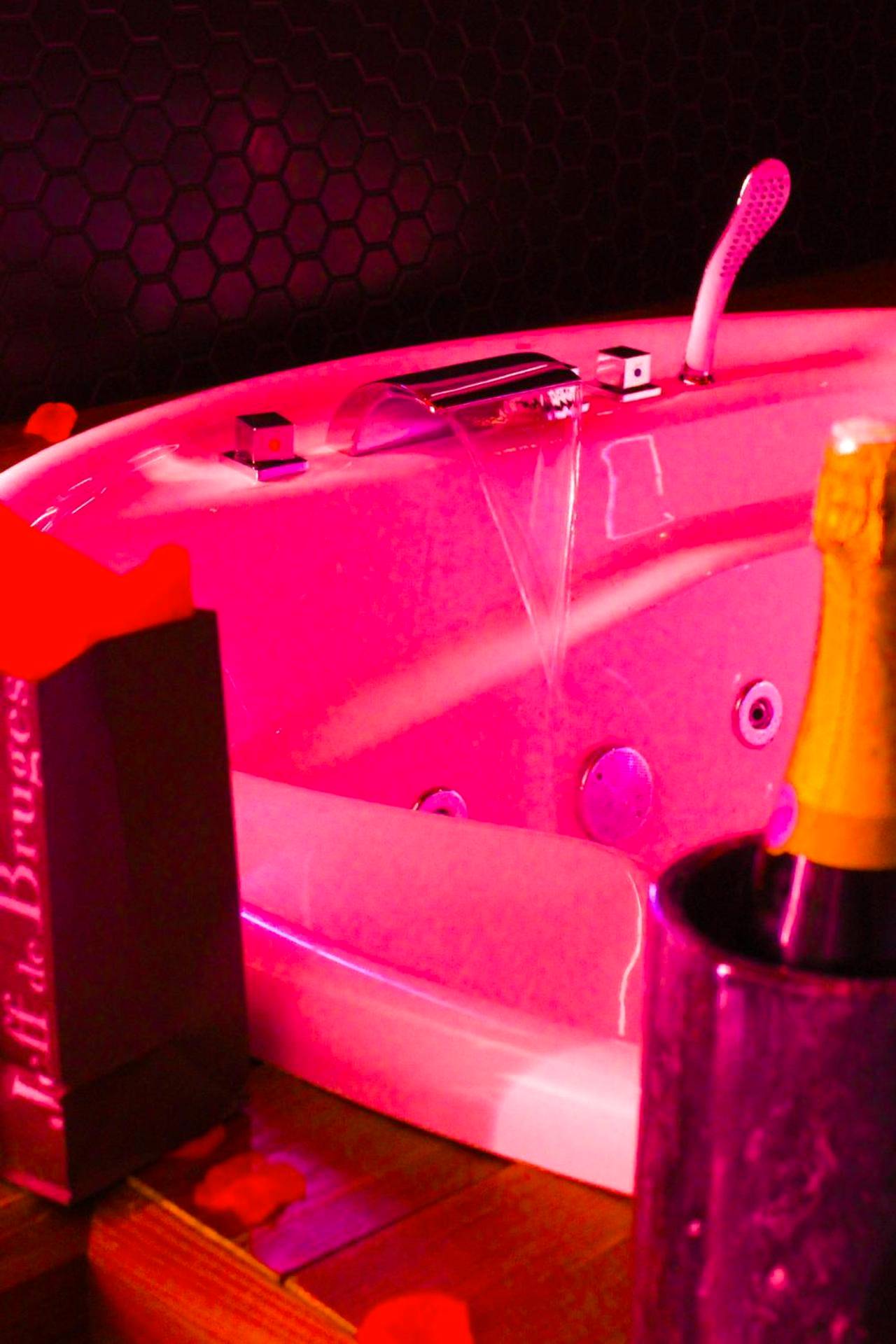Jacuzzi avec éclairage rose et champagne - Love Room Dugny - Seasides Paris - Suite Monroe