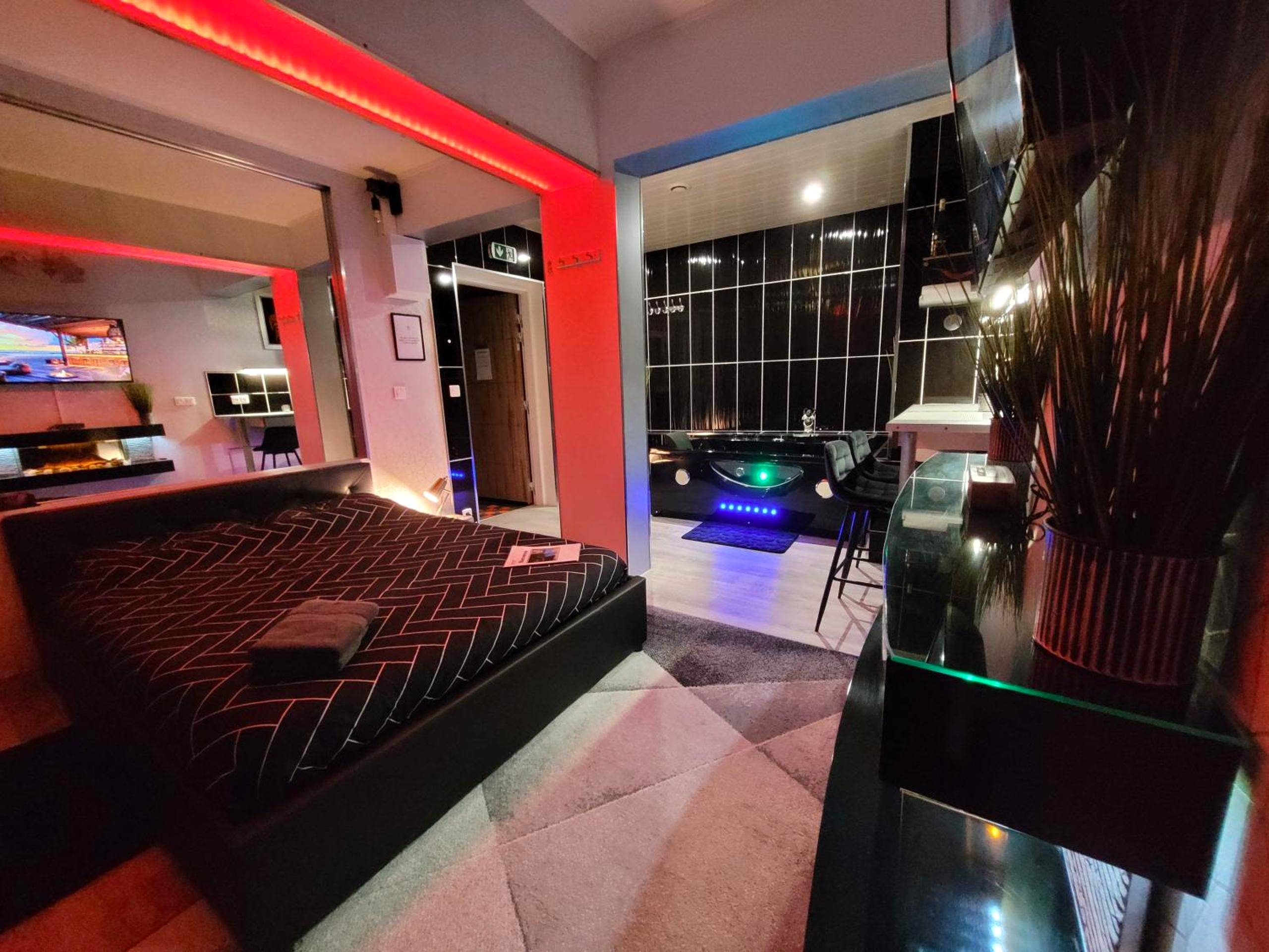 Chambre avec lit double et jacuzzi en arrière - plan - Secret Love Jacuzzi ou Midnight Spa