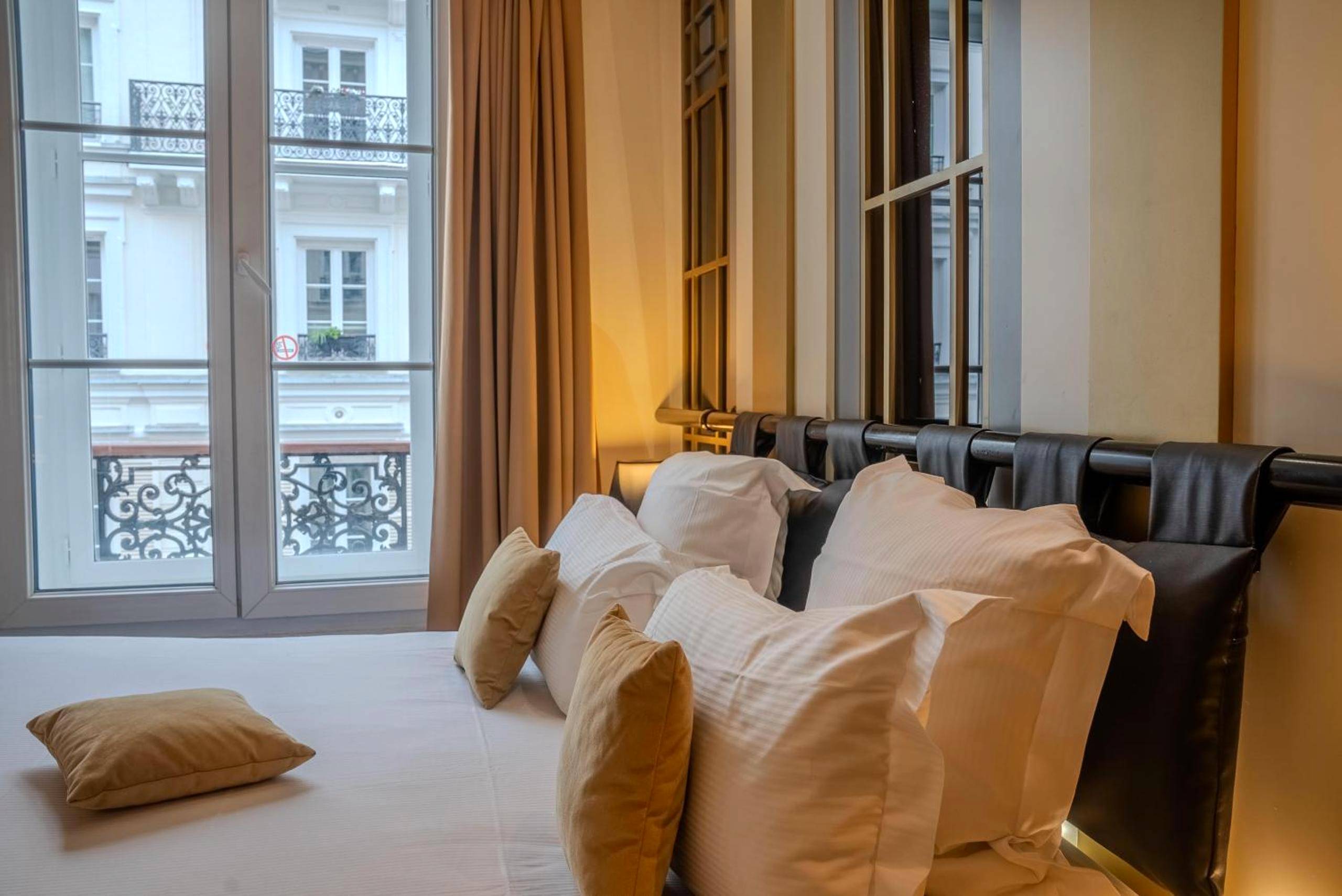 Détail du lit avec coussins et vue fenêtre - Secret de Paris - Hotel & Spa
