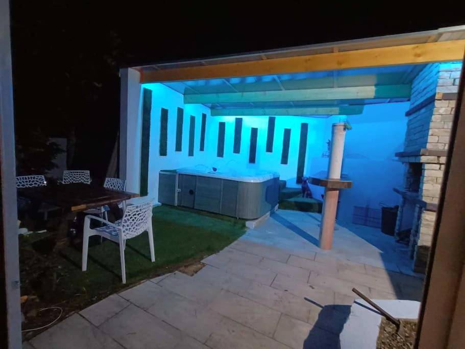 Jacuzzi extérieur sous abri avec néons bleus - Appartement Le Secret Spa billard sensualité