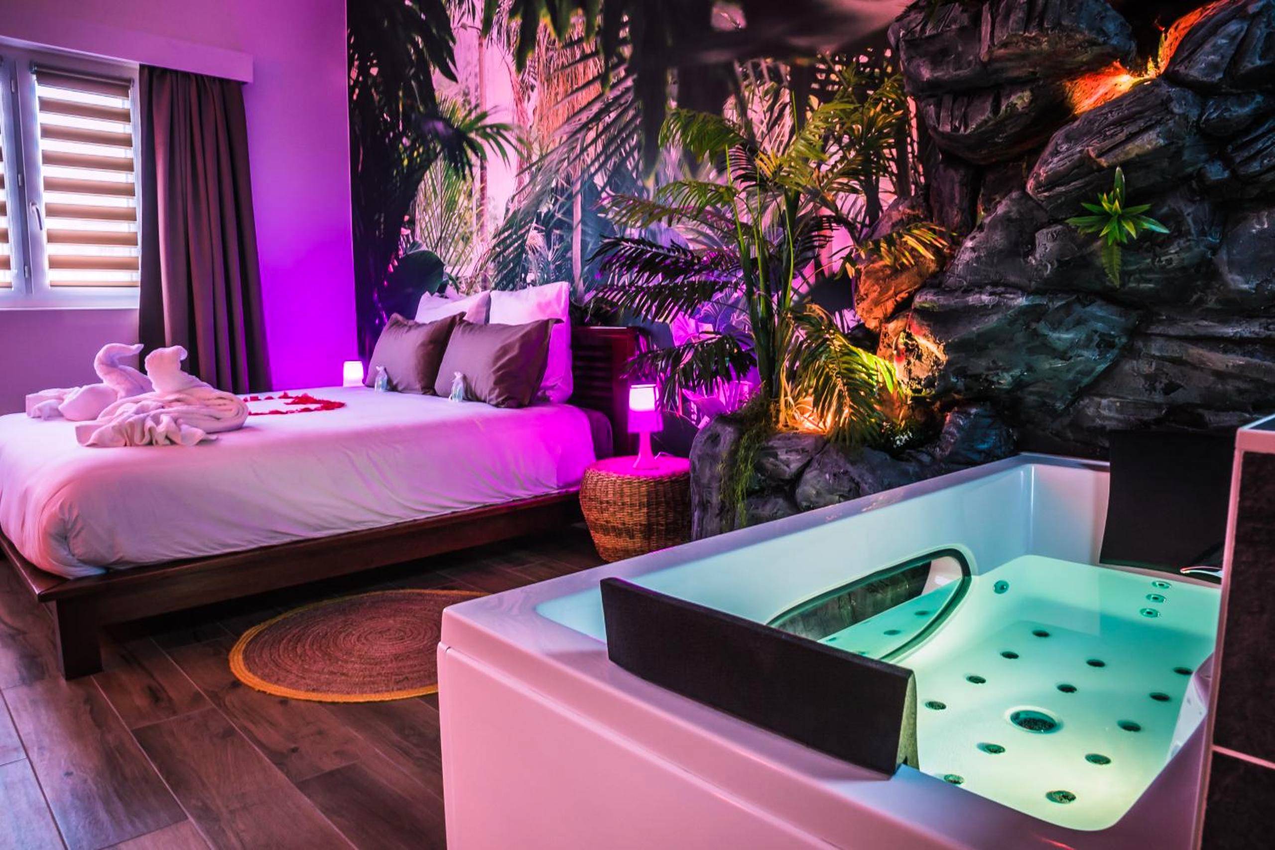 Lit double et jacuzzi avec ambiance jungle - Love Room Brétigny - sur - Orge - SECRET SUITE "Jungle" - Jacuzzi privatif...