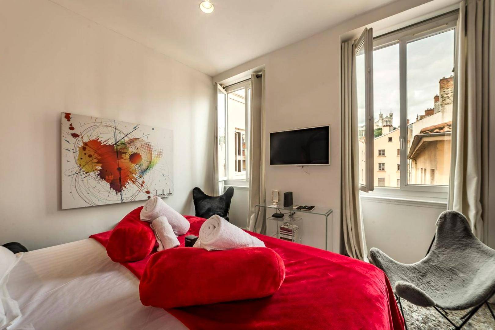 Chambre avec lit rouge et vue sur la ville - Love Room Lyon - Le secret des Templiers