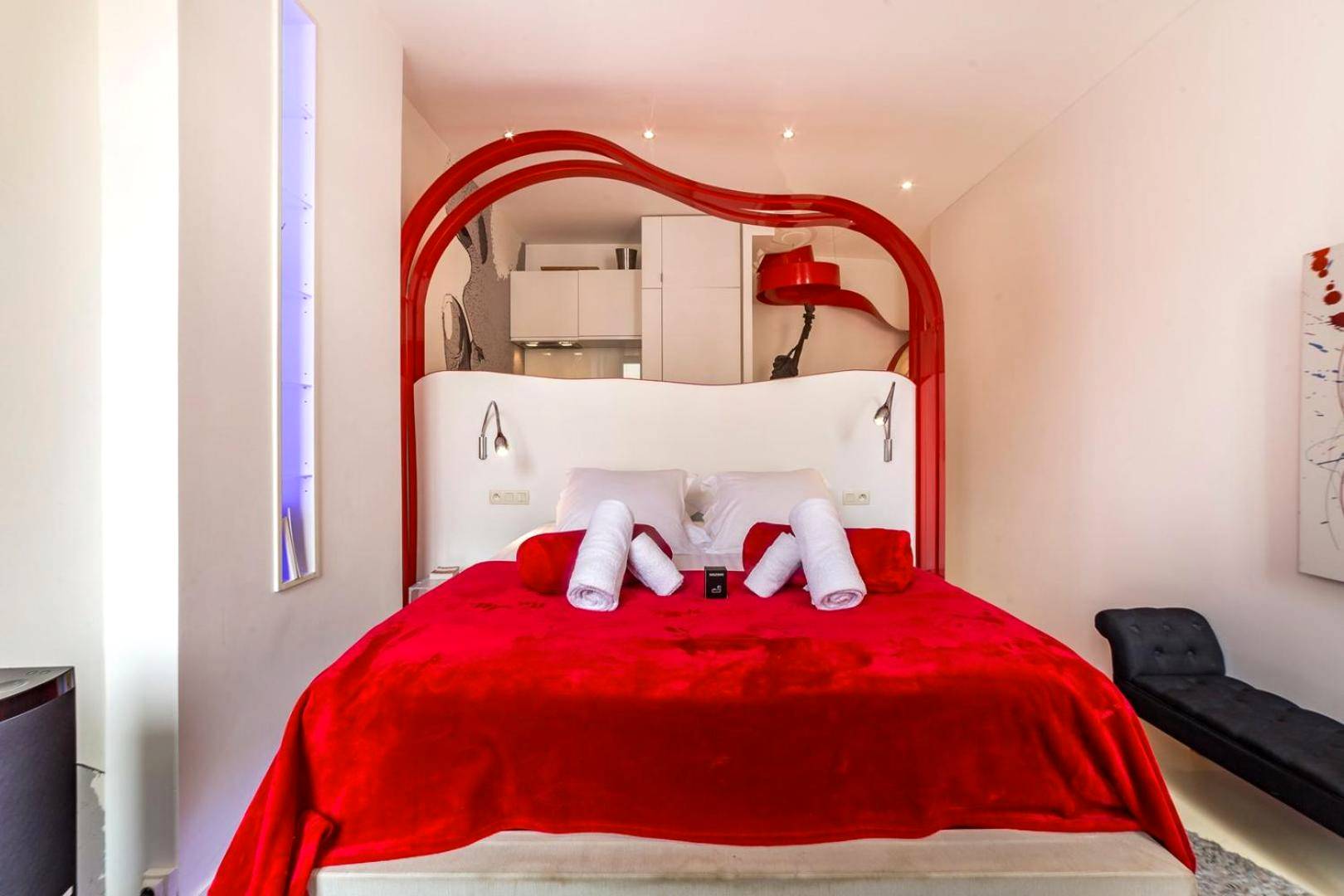 Lit double avec jeté rouge et arche design - Le secret des Templiers