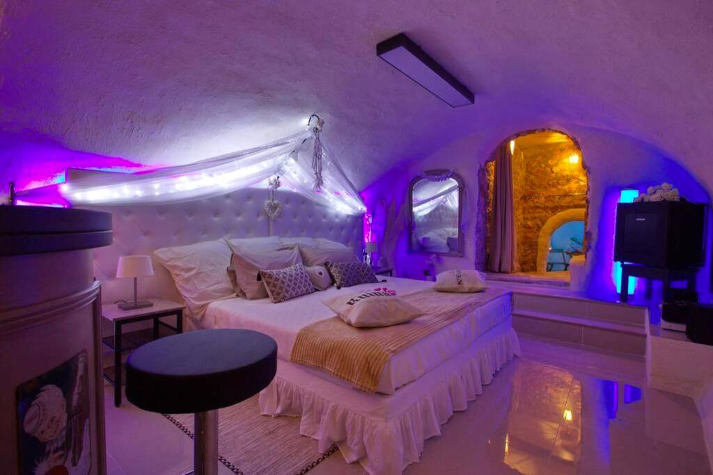 Chambre voûtée avec lit king size et néons violets - Love Room Aix - en - Provence - Les Secrets d'Alcôve, nuits...