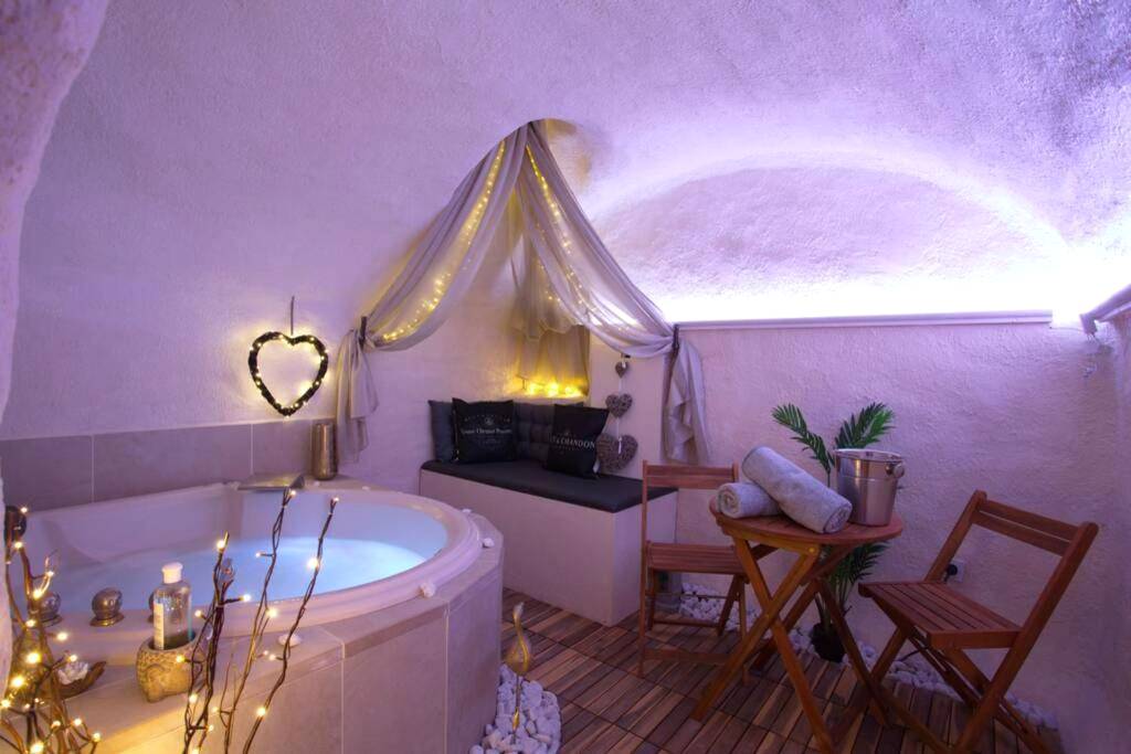 Baignoire balnéo éclairée et coin détente - Les Secrets d'Alcôve, nuits Romantiques avec SPA