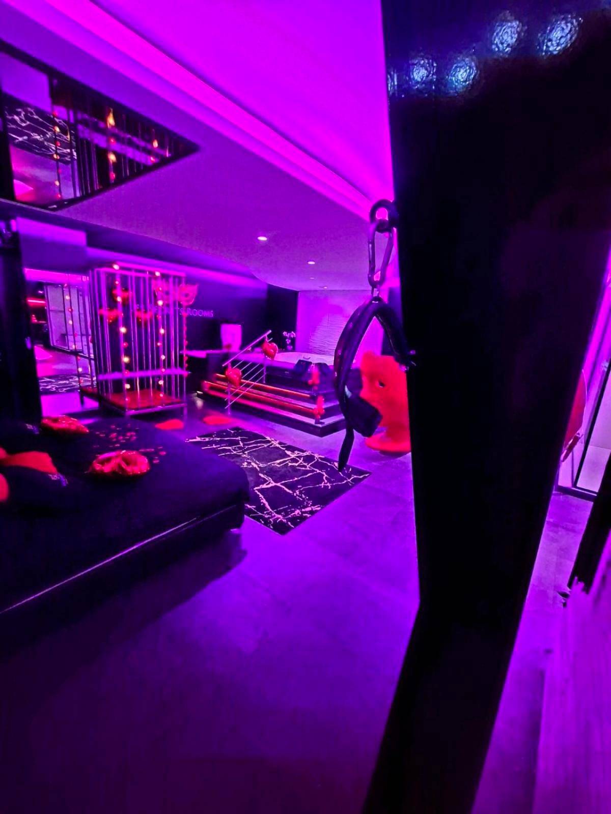 Vue d'ensemble avec lit et accessoires BDSM - Les Secrets Rooms
