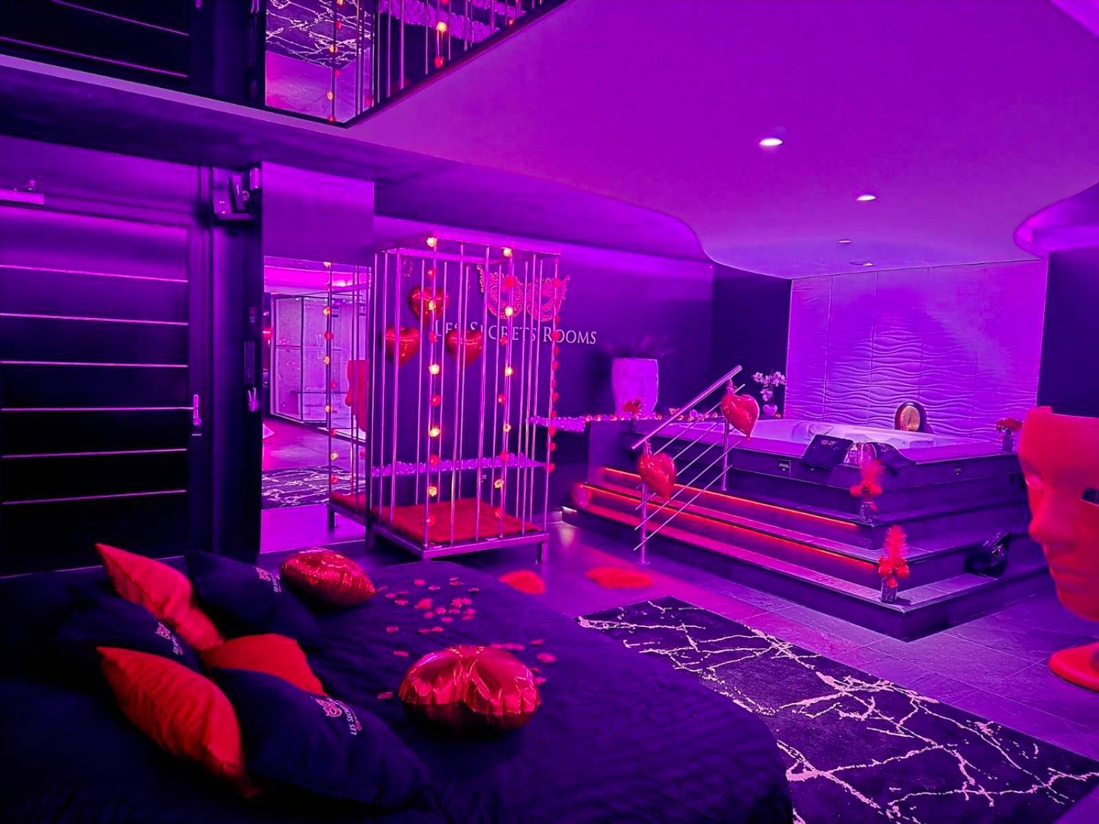 Lit king size avec pétales et ballons cœurs - Les Secrets Rooms