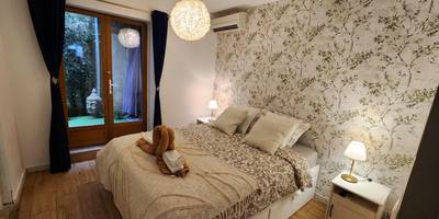 Chambre avec lit double et papier peint floral - Sérénité au Palais Suite romantique Jacuzzi