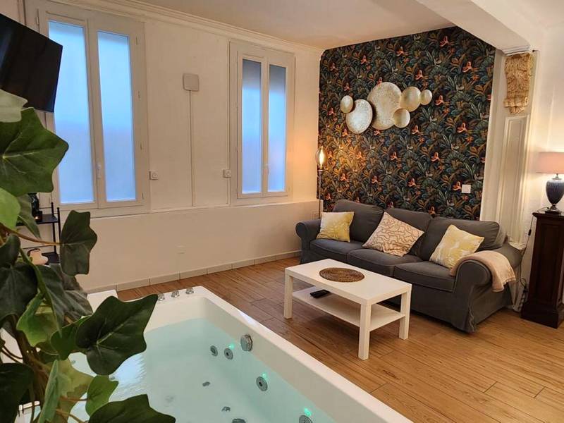 Salon avec jacuzzi privatif et mur décoratif - Sérénité au Palais Suite romantique Jacuzzi