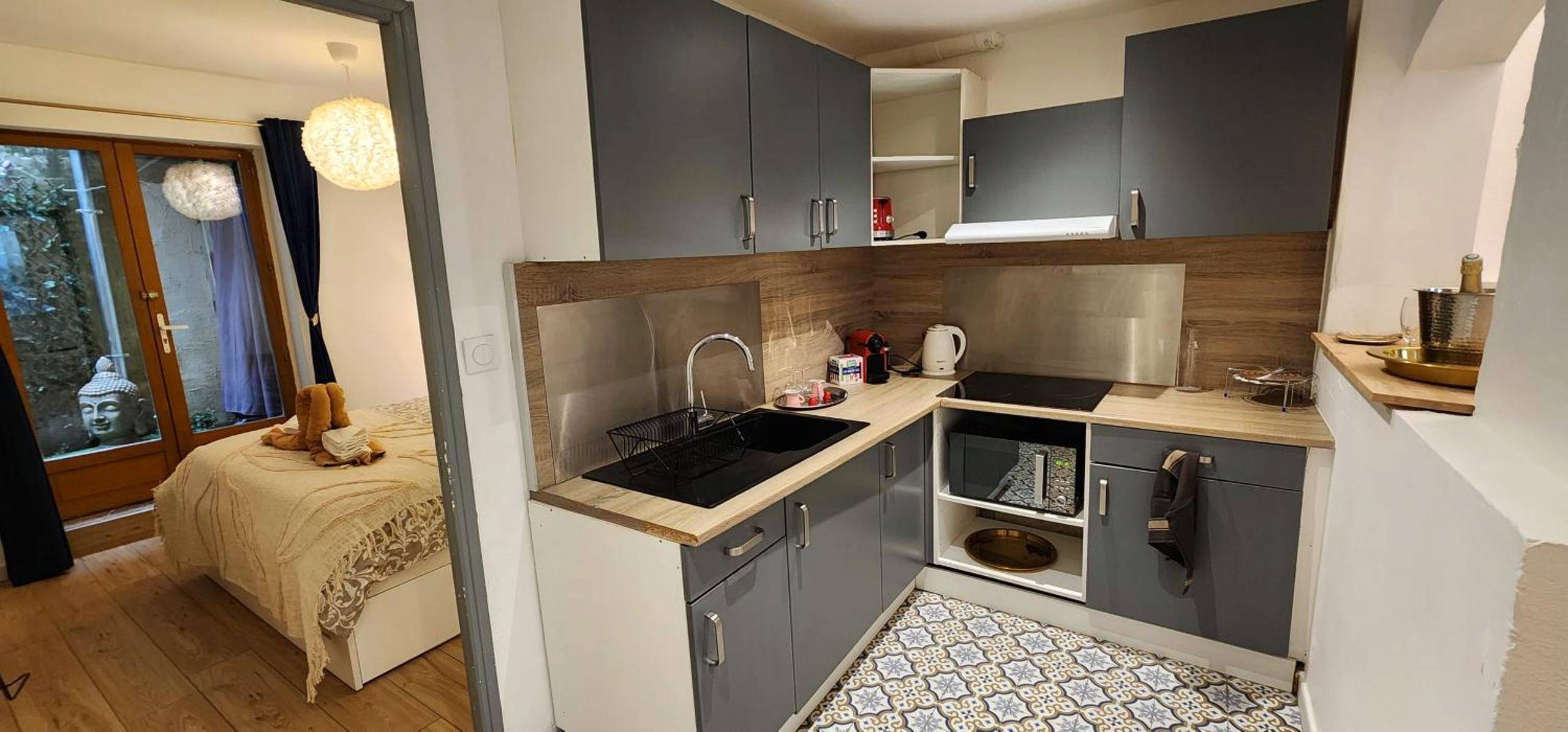 Cuisine équipée ouverte sur la chambre - Sérénité au Palais Suite romantique Jacuzzi