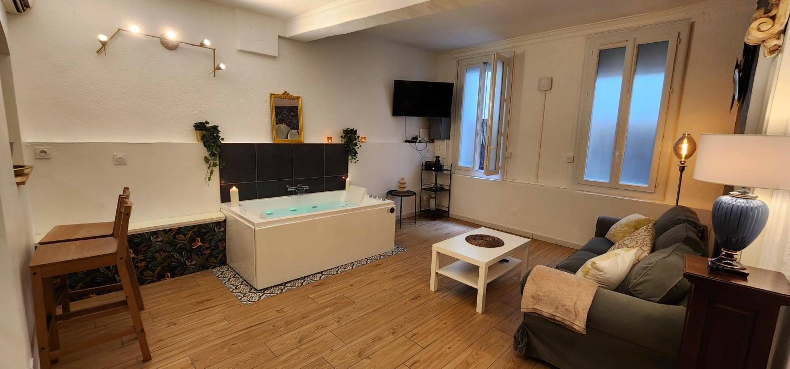 Espace de vie avec jacuzzi et coin salon - Sérénité au Palais Suite romantique Jacuzzi